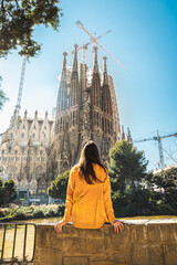 Barcelona, Spain - Tourist woman or girl looking at the church La Sagrada Familia. It is designed...