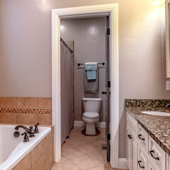 Square crop Bathroom interior with bathtub double sink vanity mirror cabinets and window