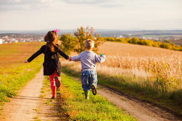 Kids have fun are running on country road