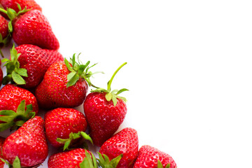 Ripe, red, fresh strawberries with elevated green tails on white background. Summer tasty fruit. Organic food. Copy space for text