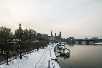 Fototapeta premium Panorama of the Terrassenufer of Dresden, Germany, in winter, at sunset. Terrassenufer is a major street of the city center of Dresde, on the waterfront riverbank of Elbe river