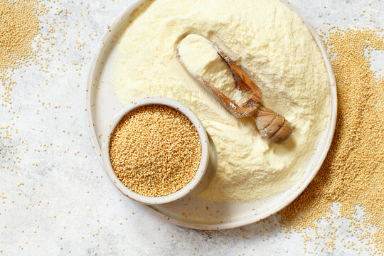 Plate of raw Amaranth flour with a scoop and Amaranth seeds