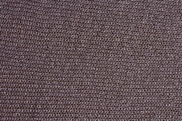 Knitted mauve background. Knitted purple textiles for text. The texture of a wool sweater. Hand knitting. Machine knitting. Purple, violet, lavender.