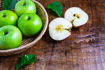 Green apple in a basket on a wooden table