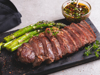 juicy roasted beef chopped steak, mutton with asparagus, close up, sauce