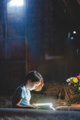 Beautiful mom and toddler blond boy, reading a book in the attic, nice atmosphere, flowers and strawberries