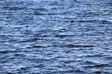 Water surface texture of deep blue sea. Soft waves, ripple water for background