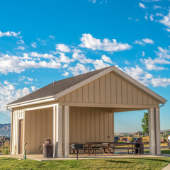 Square Building with attached picnic pavilion at a park against mountain and blue sky