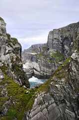 Fototapeta na wymiar Vue panoramique sur les falaises de la pointe sud de l'Irlande. Mer, rochers, vagues et écume sur fond d'eau turquoise et phare à l'horizon.