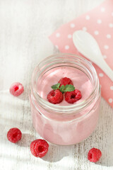 Homemade raspberries yoghurt  and raspberry berries in a jar. light background. Soft focus. pink. copy space
