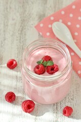 Homemade raspberries yoghurt  and raspberry berries in a jar. light background. Soft focus. pink. copy space