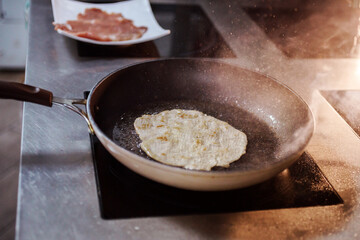 Pork meat fillet, chops, cutlet fries on the pan on the induction panel. Hot steam goes from the hot dish. 