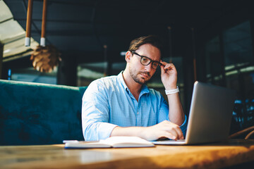 Concentrated experienced financial manager checking budget accountings working on report