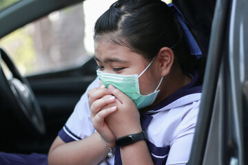 Fototapeta na wymiar Beautiful asian girl in a mask sitting in a car, protective mask against Covid-19 and Closing mouth with hand.