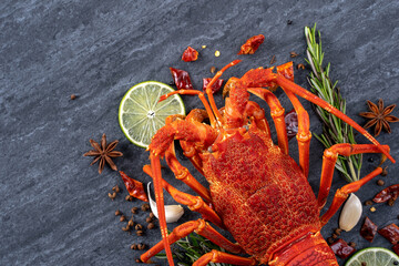 Cooked boiled lobster, delicious dinner seafood meal set with knife and fork on black stone slate background, restaurant menu design, top view, overhead