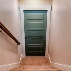 Square crop U shaped staircase that leads to the basement door from main floor of home