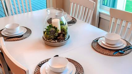 Panorama Dinner table setting with tableware on placemats arranged around a centerpiece