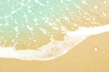 Fototapeta na wymiar Soft blue ocean wave on sandy beach with shell Background.