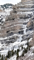 Fototapeta na wymiar Vertical Bridal Veil Falls in Provo Canyon with frozen water on steep slopes in winter