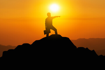 silhouette of a man on a mountain who achieve their goals