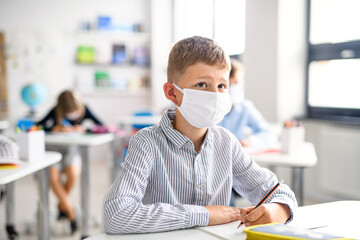 Boy with face mask back at school after covid-19 quarantine and lockdown.
