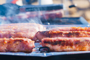 Sausages meat grilling on gas grill