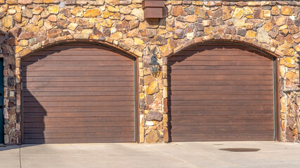 Panorama crop Front door and two arched garage doors of a home in Park City Utah neighborhood