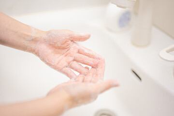 Fototapeta premium 清潔な洗面所で石鹸で手を洗う人