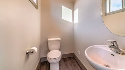 Panorama crop Bathroom of home with free standing sink round mirror toilet and wooden floor