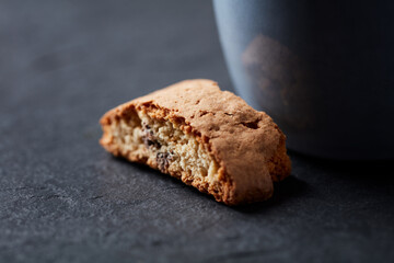Cantuccini (Italian biscuits) with a cup on dark stone background. Close up.   
