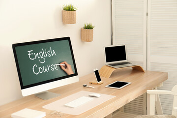 Modern computer for online English learning with teacher on table indoors