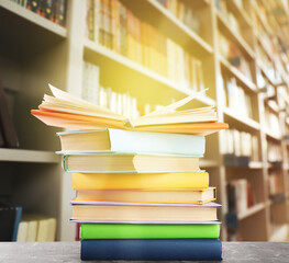 Stack of colorful books on table in library