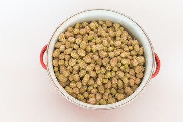 Top view mulberries in pot on white background. horizontal
