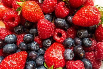 Close up view of soft summer fruits, strawberries, raspberries and blueberries.