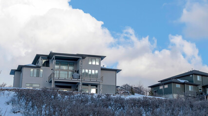 Panorama Blue sky and puffy clouds over homes on an inceredible mountain setting in winter