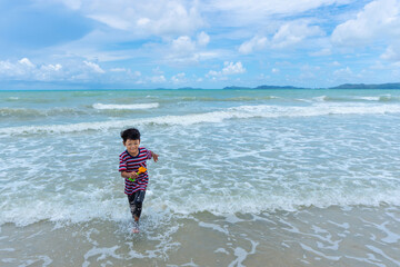 Asian kid enjoy playing in the sea