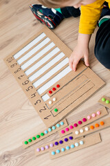 Preschool educational aid for kindergartens and home school. Put correct strap with balls of cotton wool to assigned cavity with number. Children early learning montessori kit for intelligence.