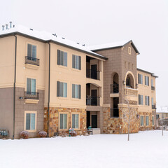 Square frame Facade of an apartment building against cloudy sky and snowy ground in winter