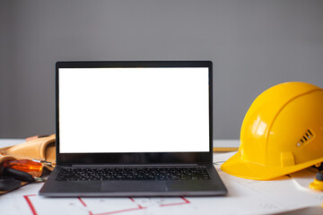 laptop and construction items, yellow helmet, apartment plan on the table, text, construction...