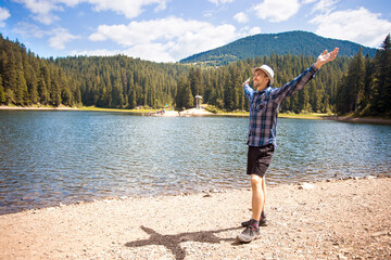 Free man with open arms near mountains lake. success. Travel and Freedom concept.