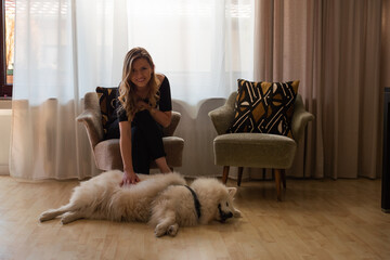 Young Blond Woman Petting Dog in Living Room