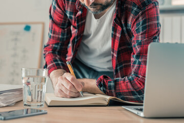 Freelancer writing notes in notebook