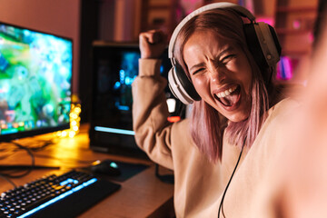 Image of excited girl taking selfie photo while playing video game