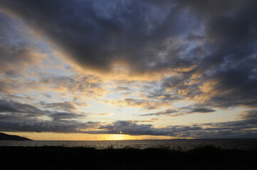 Obraz premium Beau coucher de soleil au dessus de la mer à l'ouest de l'Irlande. Vagues, nuages et ciel bleu, doré, jaune orangé.