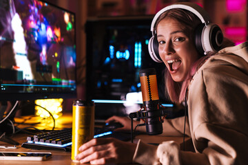 Image of excited cute girl expressing surprise while playing video game © Drobot Dean