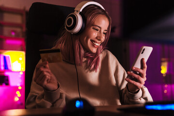 Image of excited girl holding credit card and using cellphone © Drobot Dean