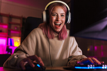 Image of excited girl in headphones smiling and playing video game © Drobot Dean