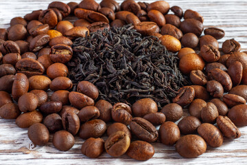 Tea leaves near coffee beans. Which is better - tea or coffee