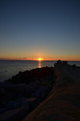 太平洋の初日の出を岩場で眺める人々