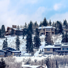 Fototapeta na wymiar Square crop Park City Utah neighborhood with homes that sit on snowy mountain in winter